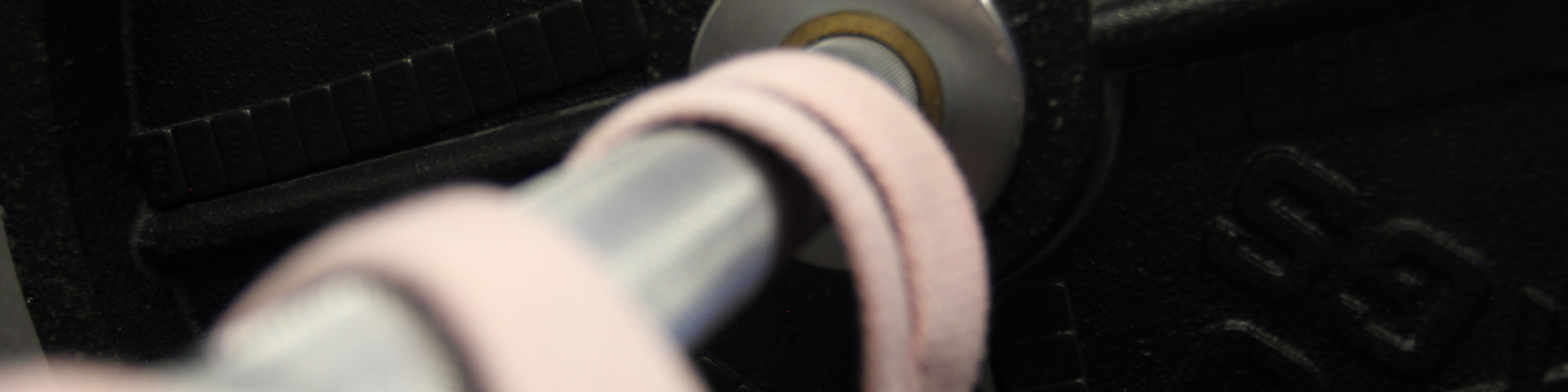 Langhantel mit 20kg beladen und 2 rosa Straps